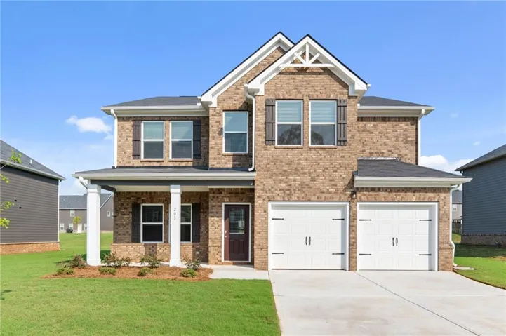 Two-story brick exterior featuring a covered front porch with white columns, a two-car garage, and dark window shutters