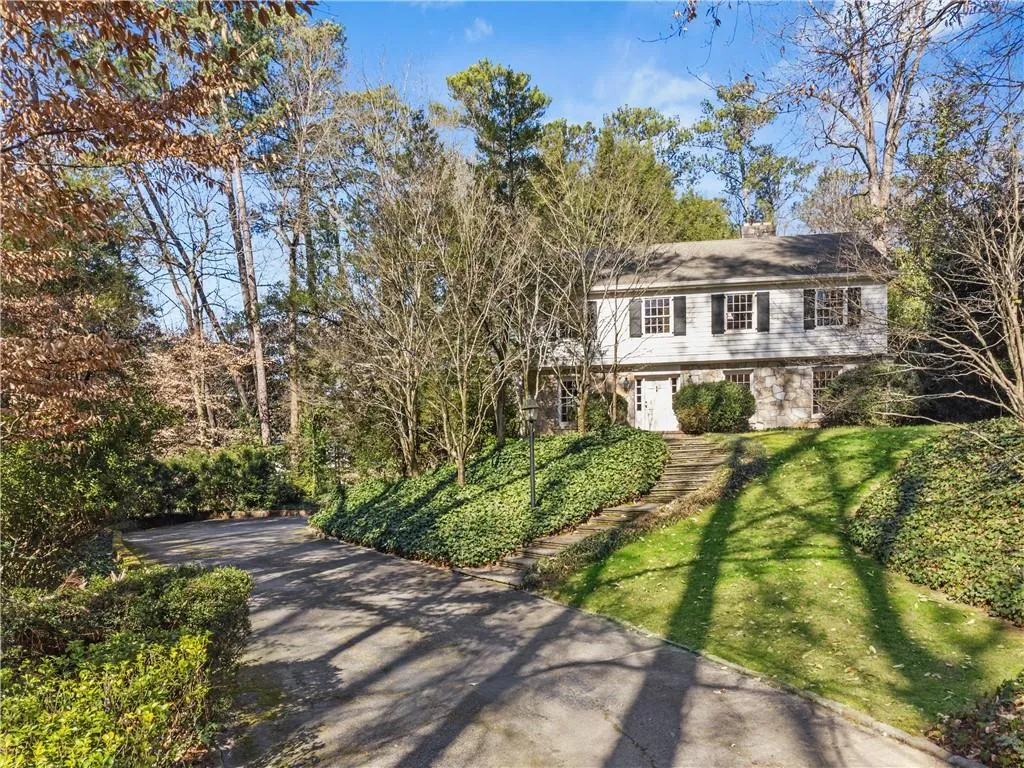 Colonial house featuring stone siding and a front yard Colonial house featuring stone siding and a front yard