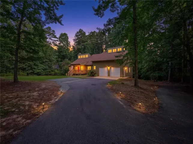 Contemporary residence with a paved driveway, two-car garage, and a welcoming covered porch