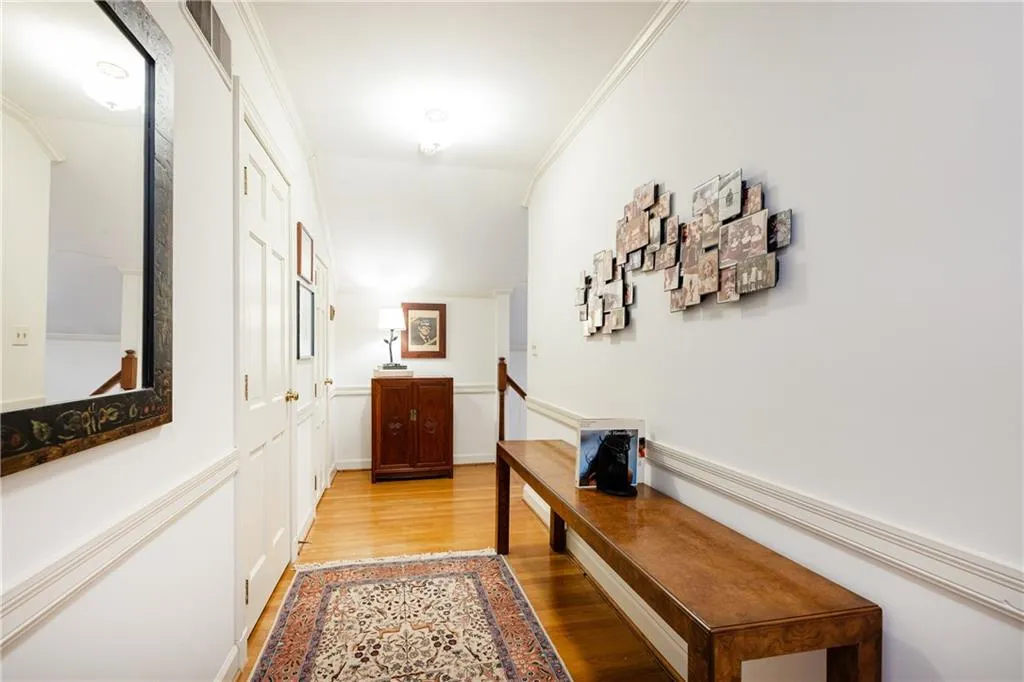 Upstairs hallway featuring light wood-style floors and crown molding