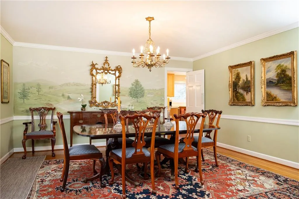 Dining area featuring a chandelier, ornamental molding, and wood finished floors
