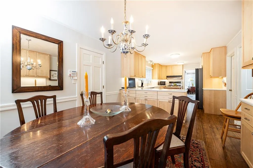 Dining area with a chandelier and dark wood-style floors