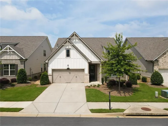 Modern farmhouse-style exterior featuring board and batten siding, a two-car garage, and a concrete driveway