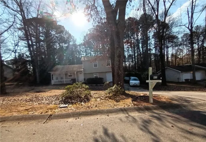 Two-story residence featuring a covered front porch and an attached garage
