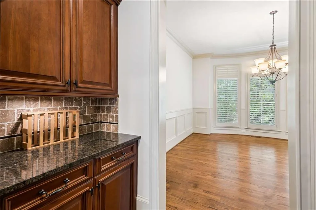 Dark wood-finish cabinetry with a granite countertop and stone-tile backsplash