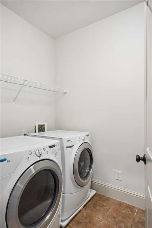Laundry area with tiled flooring and a wall-mounted wire shelf
