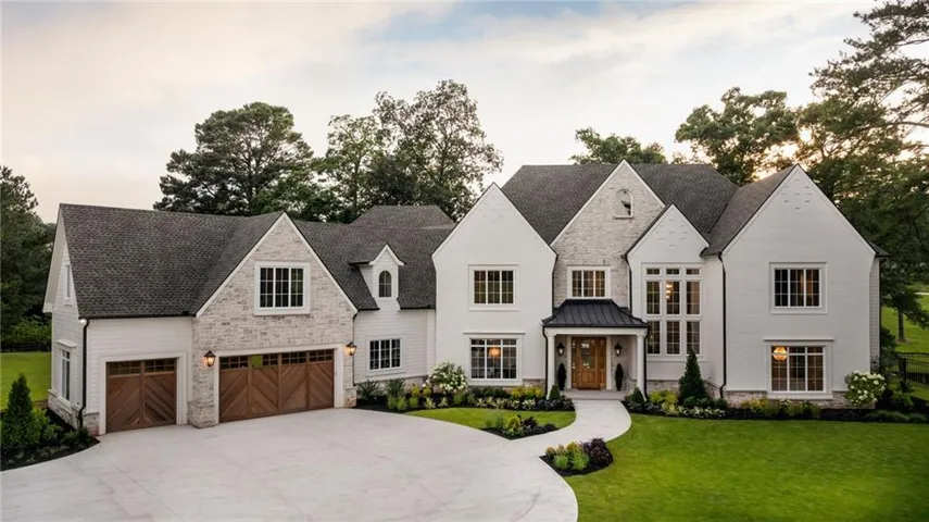 Stately white brick and stone exterior with 3 car garage and gated entrance