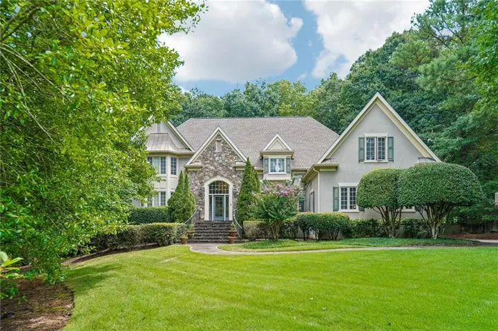 Stone and stucco exterior with multiple gables and a prominent arched entry