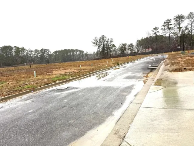 Developed land featuring paved asphalt roadway, concrete curb, and concrete sidewalk