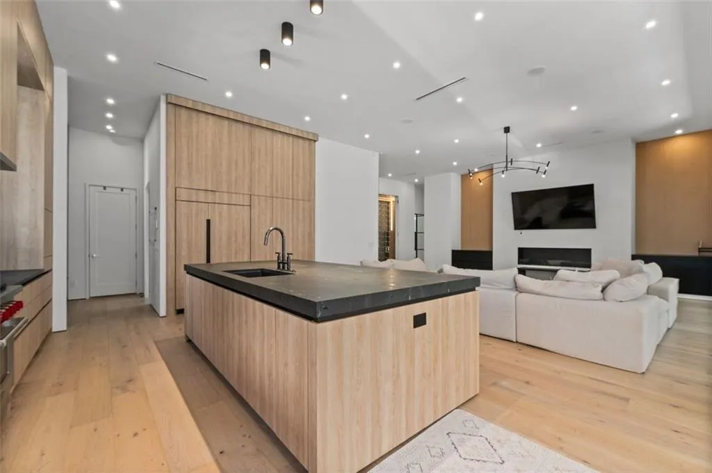 Designed for both beauty and functionality, this gourmet kitchen features custom white oak cabinetry with mitered, leathered countertops, an oversized island, and premium Wolf appliances. It seamlessly opens to the dining area and great room, making it perfect for both entertaining and everyday living.