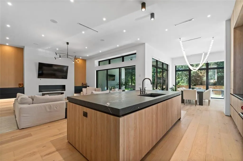Designed for both beauty and functionality, this gourmet kitchen features custom white oak cabinetry with mitered, leathered countertops, an oversized island, and premium Wolf appliances. It seamlessly opens to the dining area and great room, making it perfect for both entertaining and everyday living.