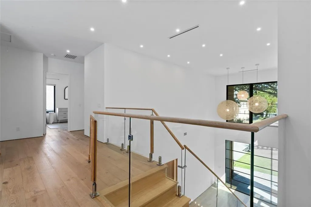 Bright and airy, this loft features a built-in entertainment center, a glass railing overlooking the foyer, and abundant natural light, making it a versatile space for relaxation or work.