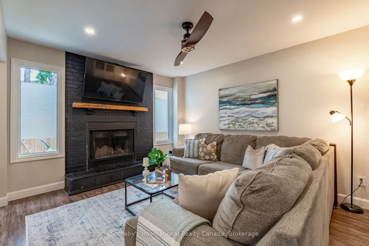 Living room with wood fireplace, open to kitchen.