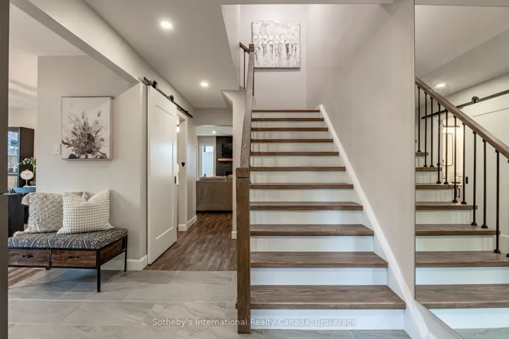 Elegant red oak staircase w/black iron railings.
