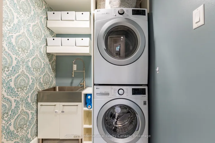 Laundry room with stackables & utility sink.