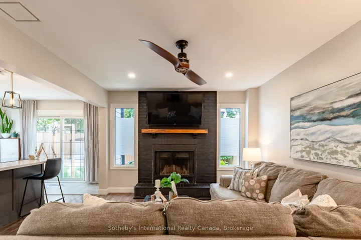 Living room with wood fireplace, open to kitchen.