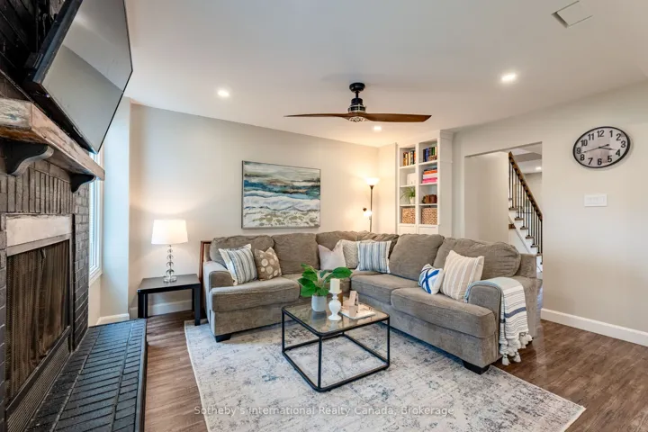 Living room with wood fireplace, open to kitchen.