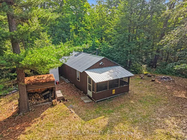Front of cabin with wood shed.