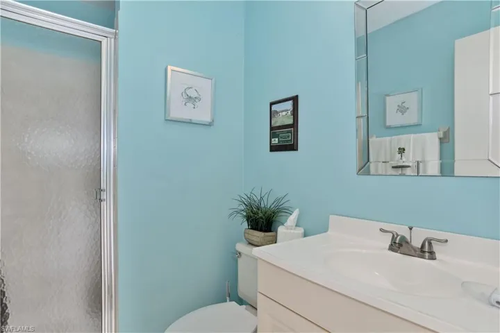 Designated Pool Bathroom featuring vanity, toilet, and an enclosed shower