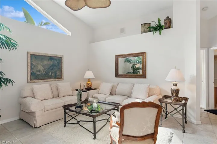 Tiled living room with high vaulted ceiling and ceiling fan