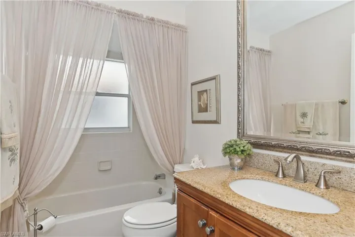 Full bathroom with vanity, toilet, and shower / bath combo with shower curtain