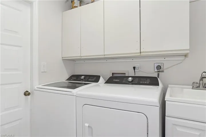 Washroom featuring cabinets and washing machine and dryer