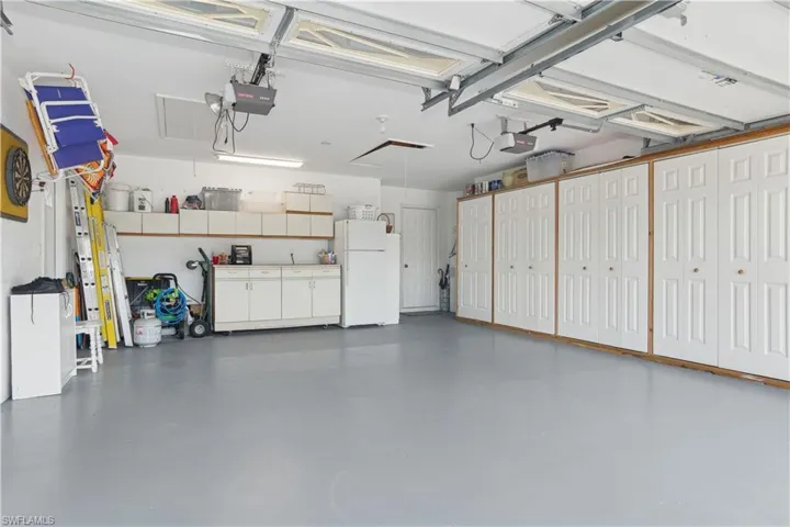 Epoxy finished garage featuring white fridge and a split drs with openers.