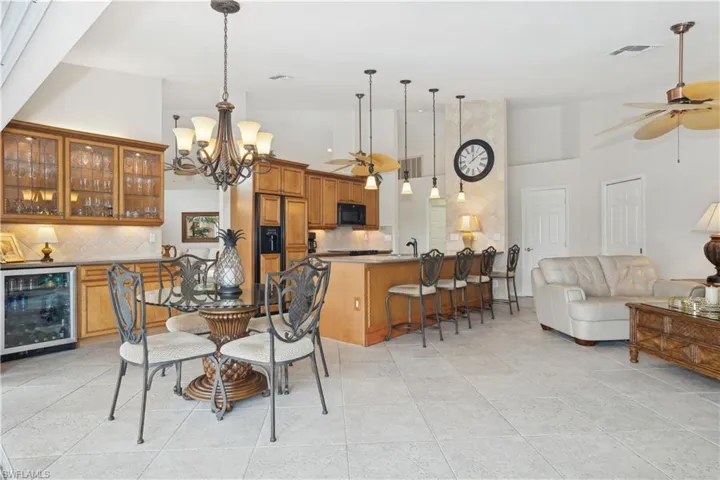 Dining space with high vaulted ceiling, beverage cooler, and indoor wet bar