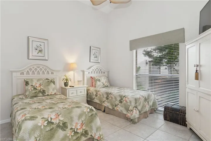 Bedroom with ceiling fan and a high ceiling