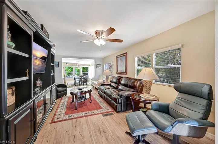 Living room with ceiling fan and light wood-type flooring