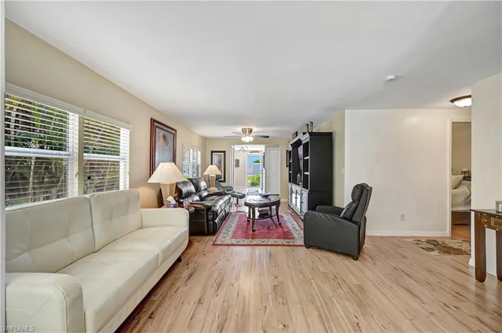 Living room featuring ceiling fan, a healthy amount of sunlight, and light hardwood / wood-style floors