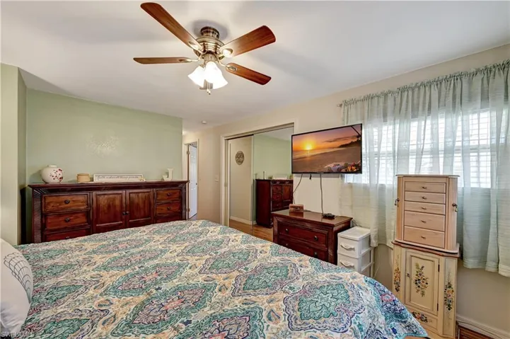 Bedroom with ceiling fan, a closet, and hardwood / wood-style flooring