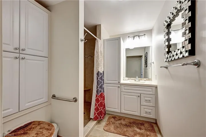 Bathroom featuring tile flooring and vanity with extensive cabinet space
