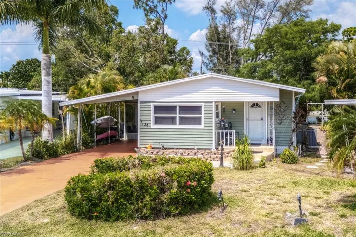 View of front of house featuring a carport, a front yard, and covered porch