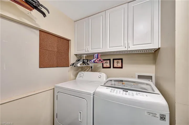 Clothes washing area with separate washer and dryer, washer hookup, and cabinets