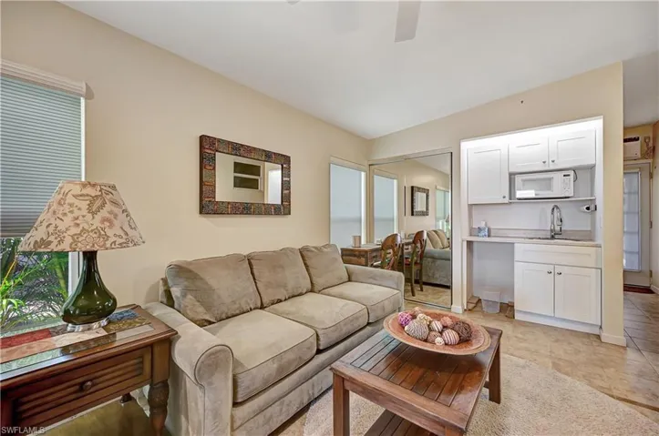 Tiled living room with sink, lofted ceiling, and a wall mounted AC