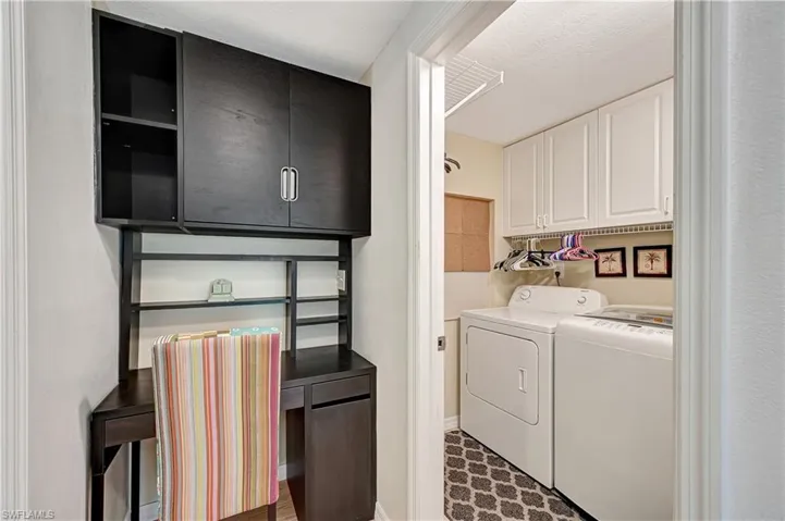 Laundry area featuring separate washer and dryer and cabinets