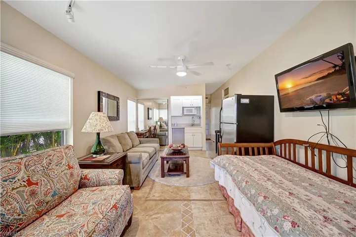 Tiled living room with ceiling fan, sink, and rail lighting