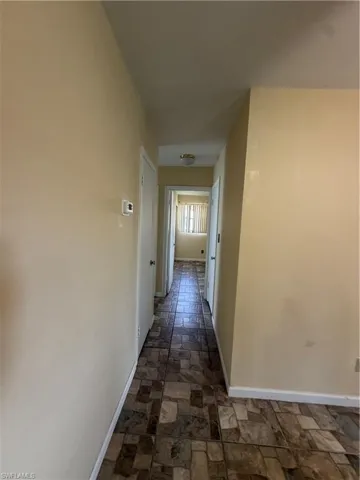 Hallway with patterned tile flooring and neutral-toned walls