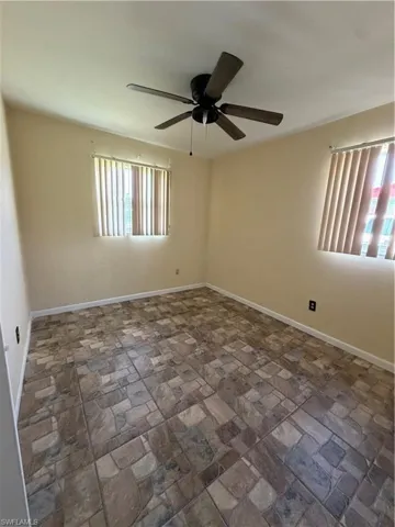 BedRoom featuring patterned tile flooring, light-toned walls, and multiple windows with vertical blinds