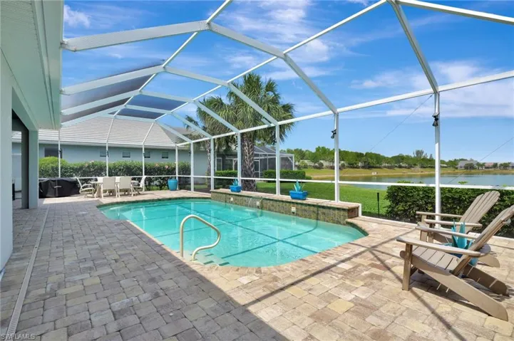 View of pool featuring a fenced in pool, glass enclosure, a water view, and a patio