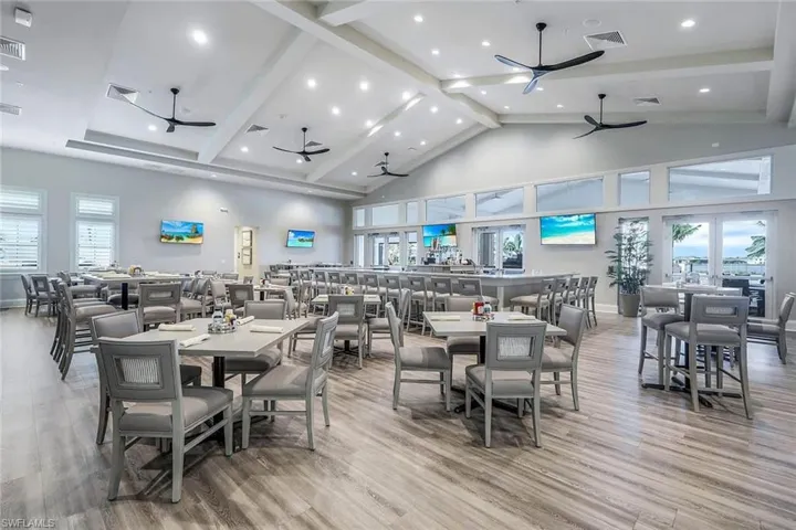 Spacious open-concept dining area featuring vaulted ceilings, recessed lighting, and wood-finish flooring