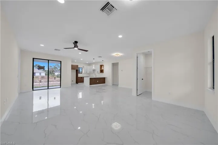 Unfurnished living room with recessed lighting, light marble finish floors, and a ceiling fan