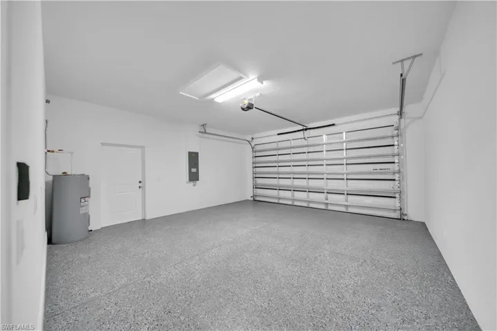 Garage featuring water heater and electric panel