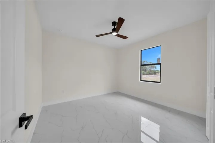 Unfurnished room with marble finish flooring and ceiling fan
