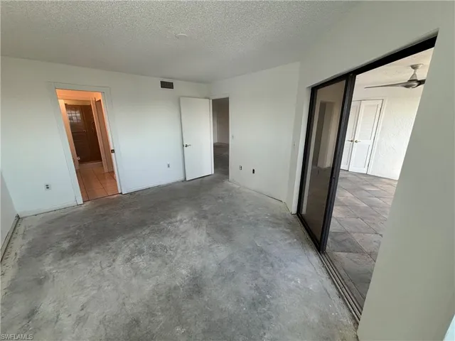 Unfurnished bedroom featuring concrete flooring and a textured ceiling