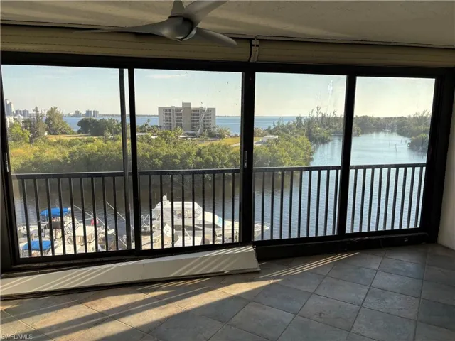Unfurnished sunroom with a water view and ceiling fan