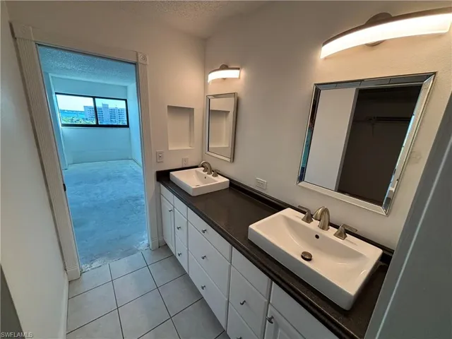 Bathroom with vanity, tile patterned floors, and a textured ceiling