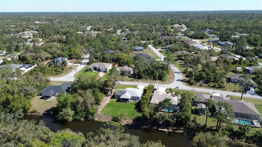 Birds eye view of property featuring a residential view, a water view, and a wooded view
