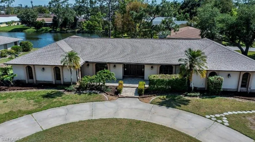 Ranch-style home with a water view and a front lawn